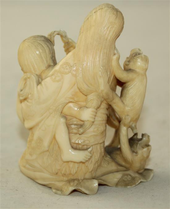 A Japanese ivory okimono of a mother suckling a child, Meiji period, 7.7cm